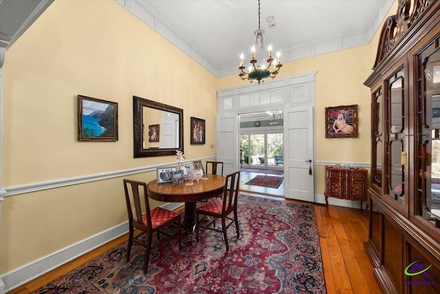 dining space featuring a chandelier, crown molding, and dark hardwood / wood-style flooring