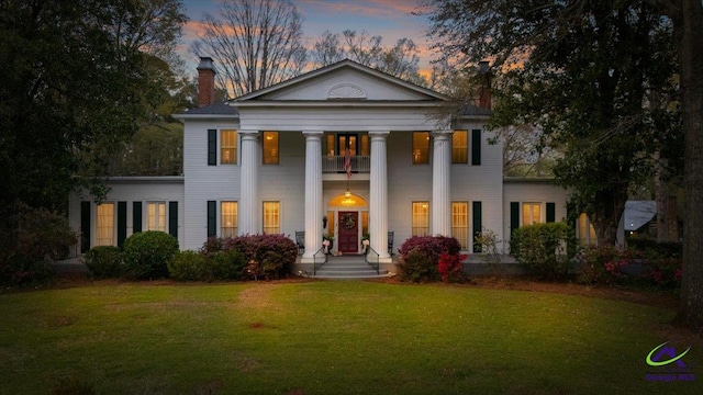 greek revival house featuring a lawn and a porch