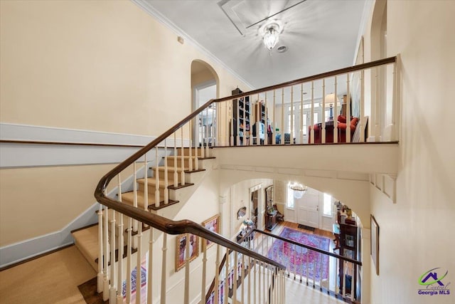 stairs with crown molding, carpet floors, and a wealth of natural light