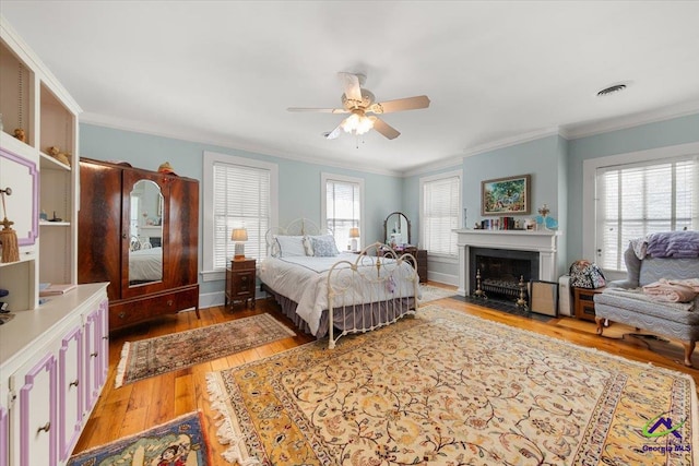 bedroom with ceiling fan, crown molding, and hardwood / wood-style flooring