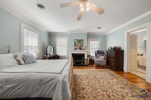 bedroom featuring ceiling fan, ornamental molding, multiple windows, and dark hardwood / wood-style floors