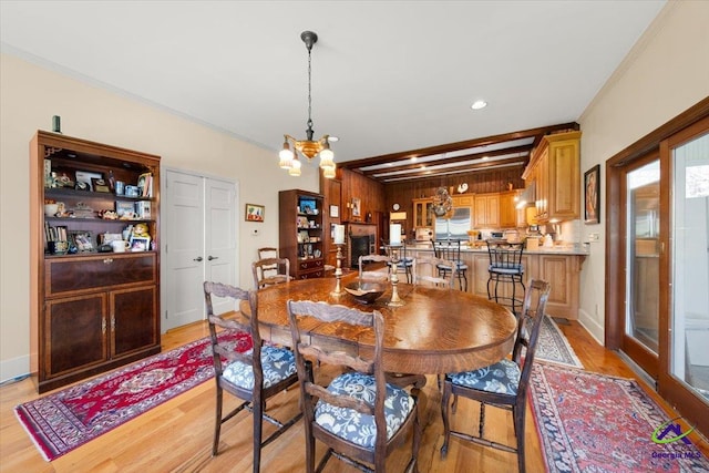 dining room featuring an inviting chandelier, beam ceiling, and light wood-type flooring