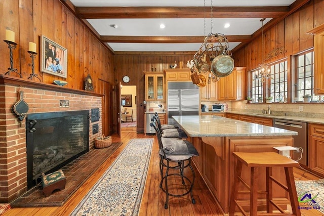 kitchen with a kitchen bar, a fireplace, light stone countertops, and dark hardwood / wood-style flooring