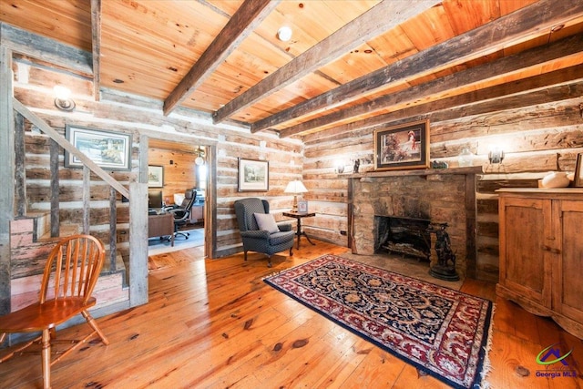 living room featuring light wood-type flooring, beamed ceiling, rustic walls, and wooden ceiling