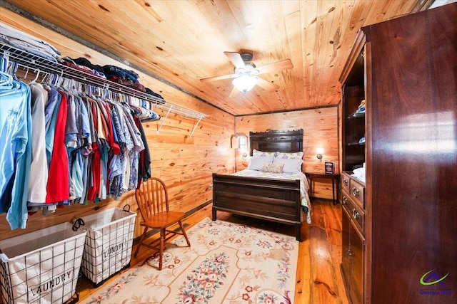 bedroom featuring wooden ceiling, ceiling fan, wood walls, and light hardwood / wood-style floors