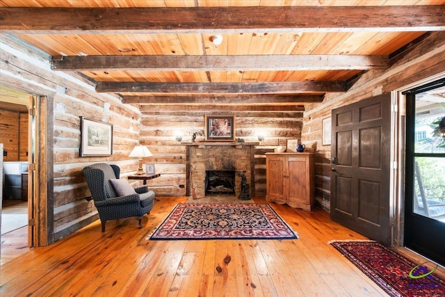 interior space featuring beam ceiling, rustic walls, and light wood-type flooring