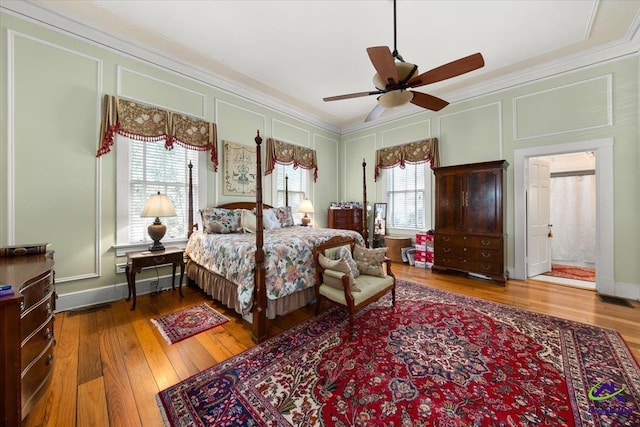 bedroom featuring multiple windows, hardwood / wood-style flooring, and ceiling fan