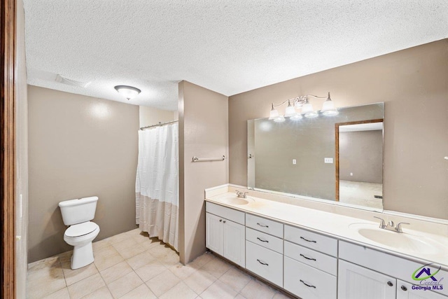 bathroom featuring toilet, a textured ceiling, tile flooring, and double vanity