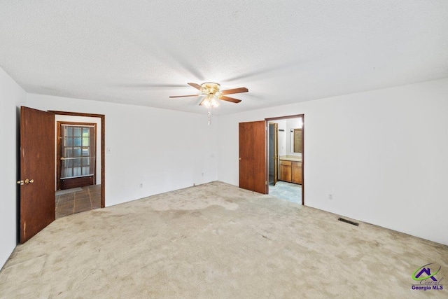 carpeted spare room with ceiling fan and a textured ceiling