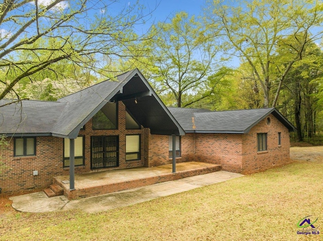 view of front of property featuring a front yard and a patio area