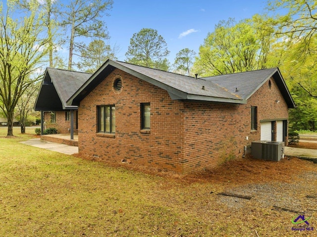 view of side of home featuring a yard, central air condition unit, and a patio area