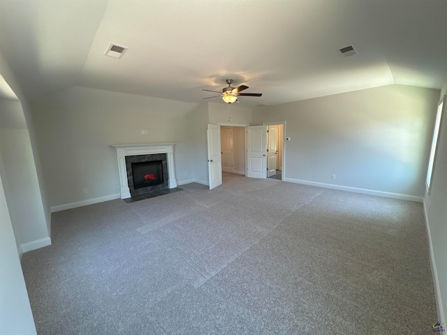 unfurnished living room with a tiled fireplace, ceiling fan, carpet, and vaulted ceiling