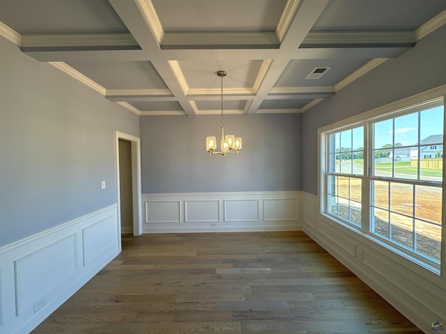 empty room featuring beamed ceiling, dark wood-type flooring, coffered ceiling, and a notable chandelier