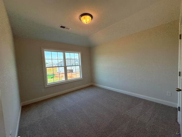 spare room with dark colored carpet