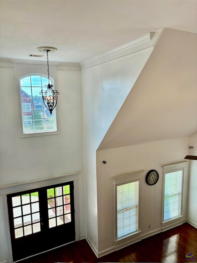 foyer entrance featuring a chandelier, dark hardwood / wood-style floors, ornamental molding, and french doors