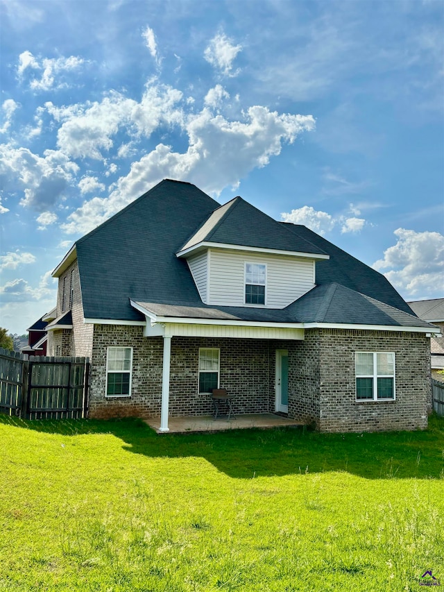 back of property featuring a lawn and a patio