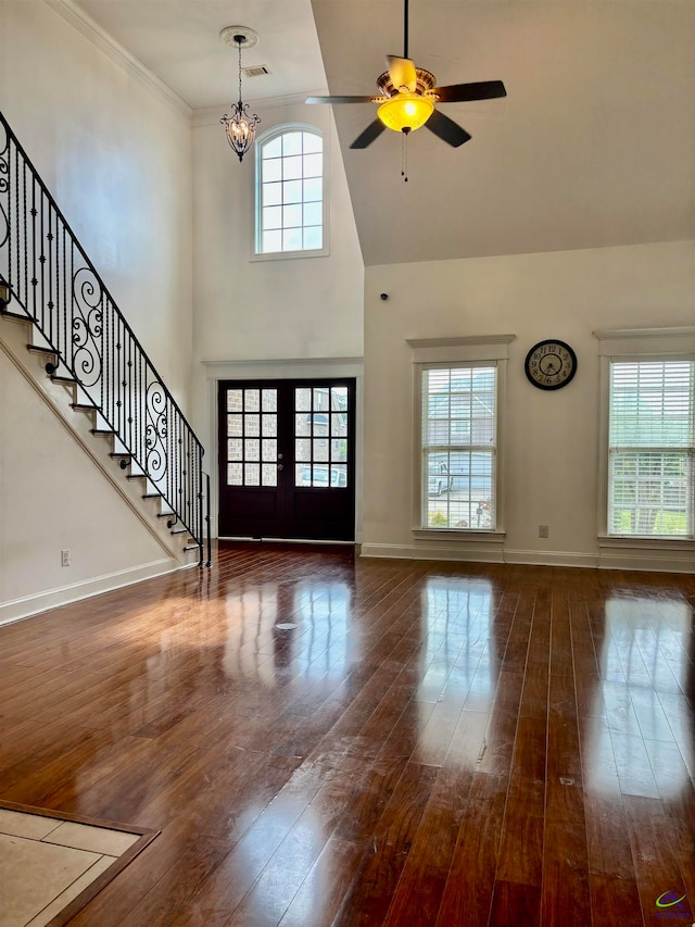 unfurnished living room with dark wood-type flooring, plenty of natural light, and french doors