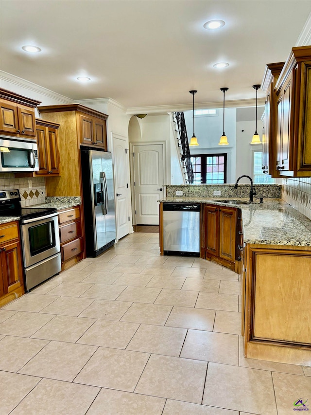 kitchen featuring appliances with stainless steel finishes, decorative light fixtures, sink, kitchen peninsula, and crown molding