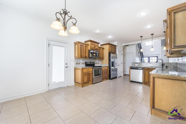 kitchen with kitchen peninsula, appliances with stainless steel finishes, tasteful backsplash, hanging light fixtures, and ornamental molding