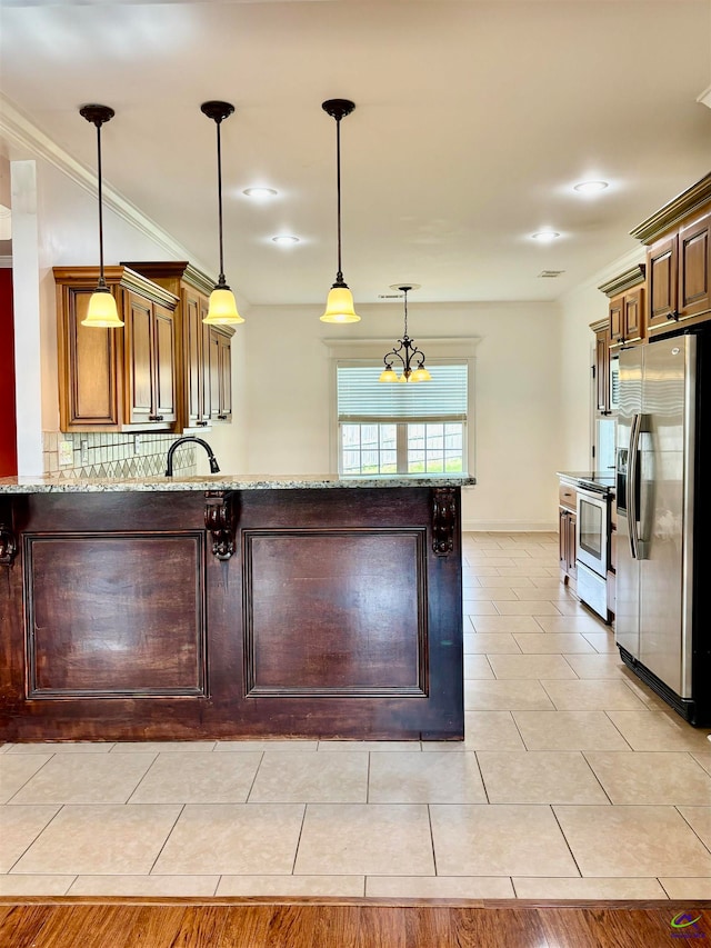 kitchen with light tile patterned floors, stainless steel appliances, light stone counters, and hanging light fixtures