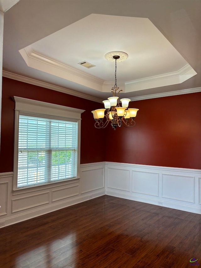 unfurnished room featuring dark wood-type flooring, a tray ceiling, crown molding, and a notable chandelier