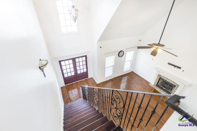 staircase featuring hardwood / wood-style floors, a healthy amount of sunlight, and french doors