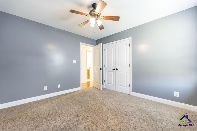 unfurnished bedroom featuring ceiling fan, carpet, and a closet