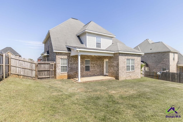 back of house featuring a patio area and a lawn