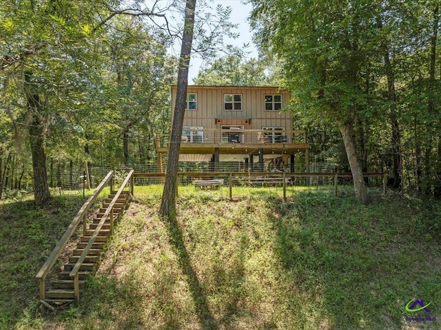 311 Riverside Dr, Hawkinsville, GA 31036 - back of property with fence, a deck, board and batten siding, and stairs