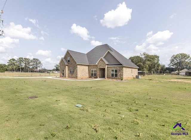 view of front facade featuring a front yard and central AC