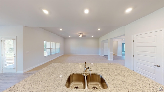 kitchen with light hardwood / wood-style floors, sink, decorative columns, and light stone countertops