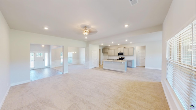 unfurnished living room with ceiling fan and light carpet