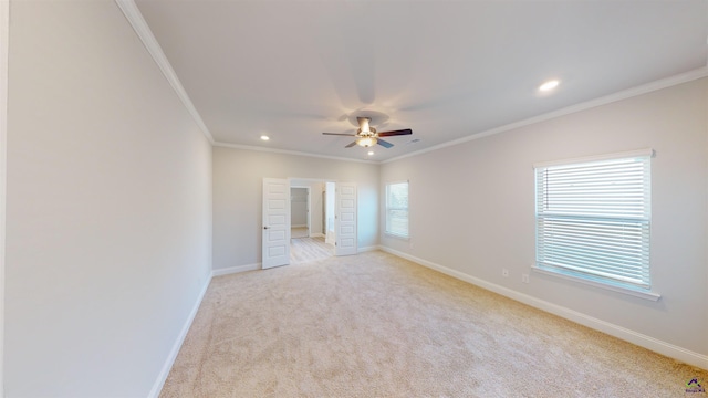 carpeted spare room with ceiling fan, a wealth of natural light, and ornamental molding