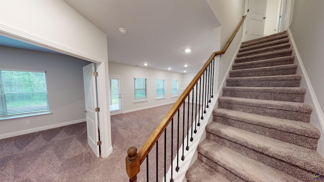 stairs with a healthy amount of sunlight and carpet flooring