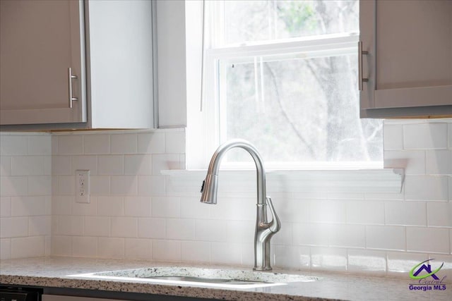 219 Carsons Walk, Macon, GA 31216 - room details featuring decorative backsplash, a sink, and light stone countertops