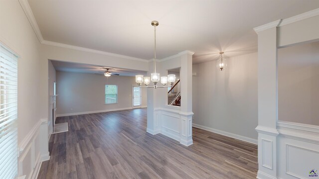 unfurnished dining area with ceiling fan with notable chandelier, dark hardwood / wood-style flooring, and crown molding