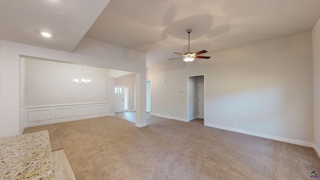 unfurnished living room with ceiling fan with notable chandelier and light colored carpet