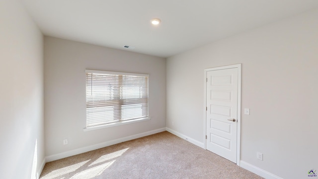 spare room featuring light colored carpet