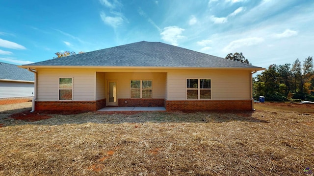 back of property featuring a patio area and a lawn