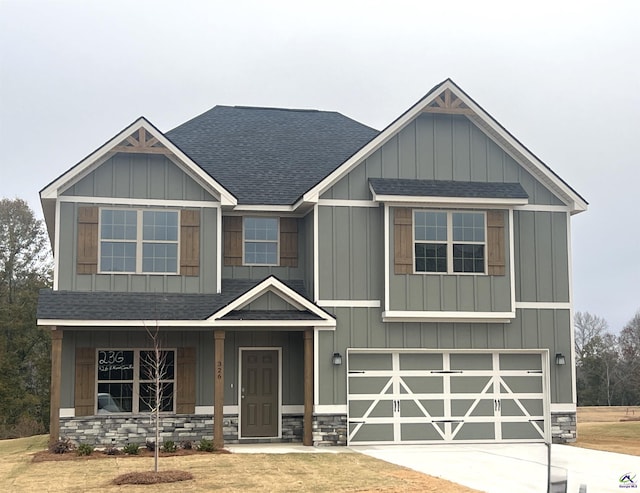 craftsman inspired home featuring a garage and a front lawn