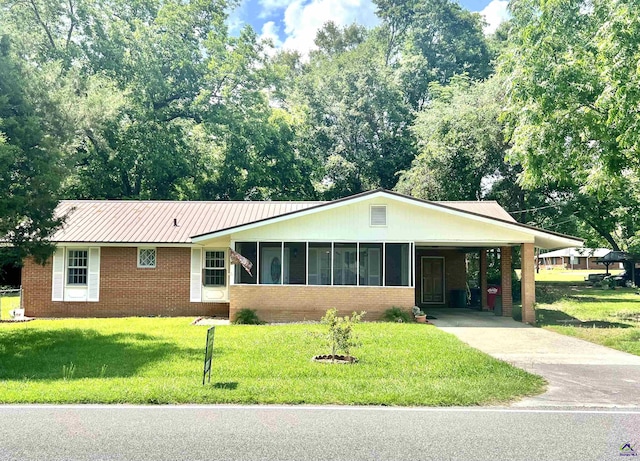 ranch-style home with a front yard, a carport, and a sunroom