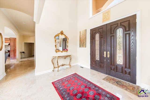 entryway with tile floors and crown molding