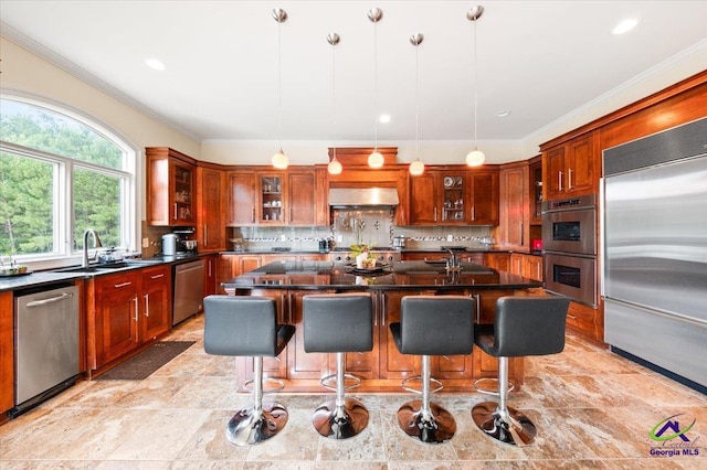 kitchen featuring a center island with sink, light tile floors, backsplash, and appliances with stainless steel finishes