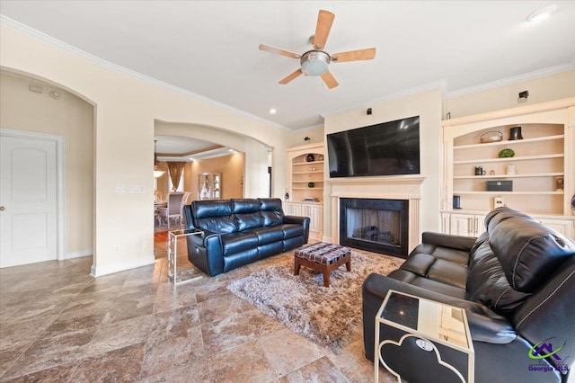 tiled living room with ceiling fan, built in shelves, and crown molding