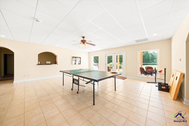 playroom featuring light tile floors, ceiling fan, french doors, and a drop ceiling