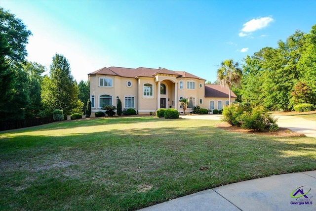 mediterranean / spanish home with a front lawn