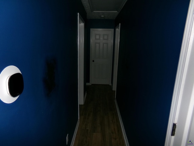 hallway with dark wood finished floors and baseboards