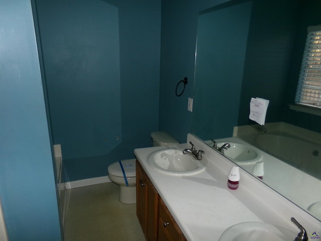 full bath featuring a tub, a sink, toilet, and double vanity