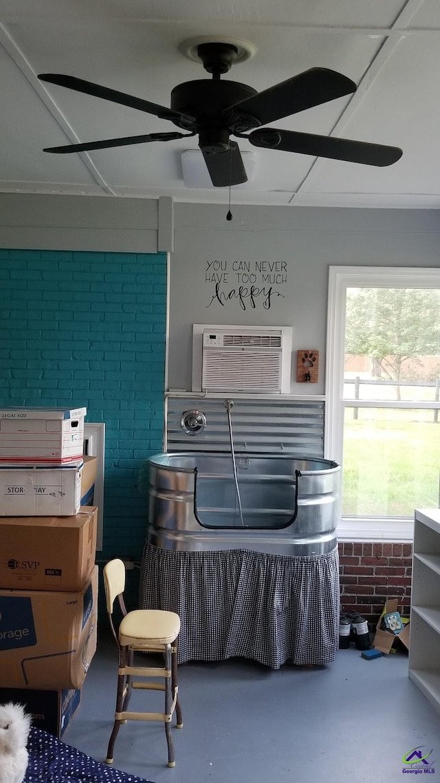 miscellaneous room featuring a wall mounted AC, brick wall, and concrete flooring