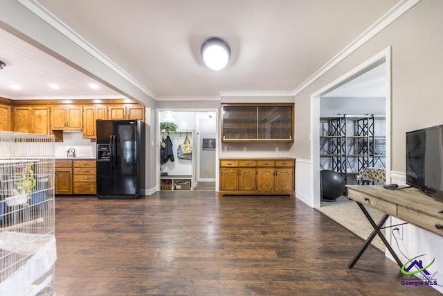 kitchen featuring black refrigerator with ice dispenser, dark hardwood / wood-style flooring, ornamental molding, and sink